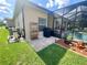 Landscaped backyard with patio, pool, grill, and tropical plants at 5005 Pebble Beach Blvd, Winter Haven, FL 33884