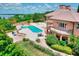 Stunning aerial view of a home showcasing the pool, landscaping, and lake views at 501 Adams Barn Rd, Auburndale, FL 33823