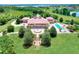 Aerial view of a grand estate featuring lush landscaping, a swimming pool, and a circular driveway at 501 Adams Barn Rd, Auburndale, FL 33823