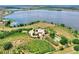 Expansive aerial shot of a property featuring a house, lake, and verdant landscaping at 501 Adams Barn Rd, Auburndale, FL 33823