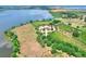 Stunning aerial view of a lakefront estate with a circular driveway and lush, mature landscaping at 501 Adams Barn Rd, Auburndale, FL 33823