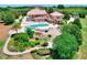Aerial view of beautiful backyard with pool, water feature, covered patio and lush landscaping at 501 Adams Barn Rd, Auburndale, FL 33823