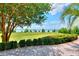 Lush backyard view showcasing a well-manicured lawn, mature trees, and a tranquil lake backdrop at 501 Adams Barn Rd, Auburndale, FL 33823