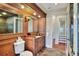 Elegant bathroom with wood cabinetry, marble floors and countertops and a marble wall treatment at 501 Adams Barn Rd, Auburndale, FL 33823