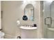 This bathroom features a toilet, sink, hair dryer and a glass enclosed shower with tiled surround at 501 Adams Barn Rd, Auburndale, FL 33823