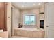 Luxurious bathroom with a soaking tub, fireplace, and shuttered window overlooking the lake at 501 Adams Barn Rd, Auburndale, FL 33823