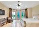 Bright bedroom boasts a ceiling fan, elegant furniture, and a view of the backyard at 501 Adams Barn Rd, Auburndale, FL 33823