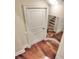 Hallway with a stylish mirror reflecting the nearby staircase and wood flooring at 501 Adams Barn Rd, Auburndale, FL 33823