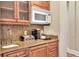 Convenient kitchenette features granite countertops, custom cabinets, microwave, and coffee maker at 501 Adams Barn Rd, Auburndale, FL 33823