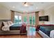Bright main bedroom with balcony access, featuring two beds and a large TV for comfortable living at 501 Adams Barn Rd, Auburndale, FL 33823