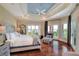 Bright main bedroom with tray ceiling, hardwood floors, balcony access and waterfront views at 501 Adams Barn Rd, Auburndale, FL 33823