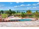 Inviting pool with lush landscaping and lake view from the tiled patio of this luxury home at 501 Adams Barn Rd, Auburndale, FL 33823
