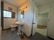 Bright bathroom with a pedestal sink, glass block window, and doorway to another room at 502 Canal Dr, Lake Wales, FL 33859