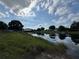 View of the pond with a dock, boathouse, and calm water at 502 Canal Dr, Lake Wales, FL 33859