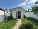Exterior of white shed with double doors, overgrown yard and white fencing at 502 Canal Dr, Lake Wales, FL 33859