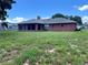Single story brick house with a large screened in patio and a generous backyard with green lawn at 504 W 7Th St, Frostproof, FL 33843