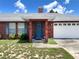 Charming brick home with a blue front door, shutters, and a well-manicured lawn under a sunny sky at 504 W 7Th St, Frostproof, FL 33843