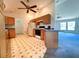 Open kitchen with wood cabinets, ceiling fan, and access to living room at 504 W 7Th St, Frostproof, FL 33843