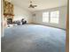 Spacious living room featuring a stone fireplace, ceiling fan, and natural light at 504 W 7Th St, Frostproof, FL 33843