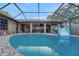 A gorgeous screened-in pool area featuring crystal clear water, a slide and an outdoor grilling area at 505 8Th S St, Dundee, FL 33838