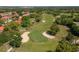 Aerial shot of a golf course with a sand trap and putting green surrounded by trees at 5102 Village Ct # E-2, Lake Wales, FL 33898