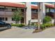 Condo exterior featuring a red tile roof, covered balcony, and well-maintained landscaping with ample parking at 5102 Village Ct # E-2, Lake Wales, FL 33898