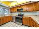 This kitchen features wood cabinets, stainless steel appliances, and white tile flooring at 5102 Village Ct # E-2, Lake Wales, FL 33898