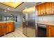 An open kitchen offers a stainless steel refrigerator, wood cabinets, and breakfast bar seating at 5102 Village Ct # E-2, Lake Wales, FL 33898