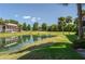 Scenic view of a pond with a fountain, lush landscaping, and a building reflecting in the water at 5102 Village Ct # E-2, Lake Wales, FL 33898