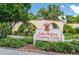 Entrance to Lake Wales Country Club, featuring a decorative sign, landscaping, and a stone waterfall at 5102 Village Ct # E-2, Lake Wales, FL 33898