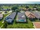 Aerial view of a home showcasing a screened-in pool and lush landscaping with golf course in the background at 560 Saint Andrews Rd, Winter Haven, FL 33884