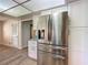 A kitchen showcases stainless steel appliances, bright white cabinetry, and wood look tile flooring at 560 Saint Andrews Rd, Winter Haven, FL 33884