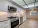 The updated kitchen offers stainless steel appliances, white cabinets, and a bright and airy feel at 560 Saint Andrews Rd, Winter Haven, FL 33884