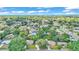 Aerial shot of a residential area with tree coverage, homes with dark shingle roofs, and a view of a lake in the distance at 616 Oriole Dr, Lakeland, FL 33803