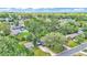 Aerial view showcases the neighborhood with lush trees and well-maintained homes under a cloudy blue sky at 616 Oriole Dr, Lakeland, FL 33803