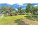 Expansive backyard with lush green lawn, mature trees, and various outdoor features at 616 Oriole Dr, Lakeland, FL 33803