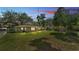 Spacious backyard featuring a well-manicured lawn, shade trees, and a patio area perfect for entertaining at 616 Oriole Dr, Lakeland, FL 33803
