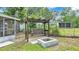 Backyard showing a fire pit and swing set with the house and screened-in porch in the background at 616 Oriole Dr, Lakeland, FL 33803