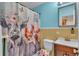Fun bathroom featuring blue walls, yellow tiles, and a whimsical animal-themed shower curtain at 616 Oriole Dr, Lakeland, FL 33803