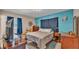 Charming bedroom featuring bright blue walls, wood furniture, and tiled floors at 616 Oriole Dr, Lakeland, FL 33803