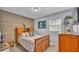 Comfortable bedroom with wood-look accent wall, window, and natural light at 616 Oriole Dr, Lakeland, FL 33803