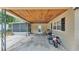 Large, partially covered carport with wood ceiling and motorcycle parked on the concrete pad at 616 Oriole Dr, Lakeland, FL 33803
