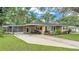 Well-maintained home with a carport, a screened-in porch, a driveway, and a lush green lawn at 616 Oriole Dr, Lakeland, FL 33803