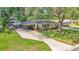 Inviting single-story home with a long driveway, mature landscaping, and covered carport for convenience at 616 Oriole Dr, Lakeland, FL 33803