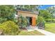Shed featuring a dark shingled roof, double doors, and tropical landscaping at 616 Oriole Dr, Lakeland, FL 33803