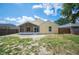 Rear view of home showing a spacious backyard, screened porch, and a well-maintained wooden fence at 630 Heather Glen Loop, Winter Haven, FL 33884