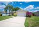 Attractive one-story house featuring lush landscaping, a palm tree, and a two-car garage at 630 Heather Glen Loop, Winter Haven, FL 33884
