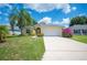 Charming one-story home with palm trees, colorful flowers, and a two-car garage at 630 Heather Glen Loop, Winter Haven, FL 33884