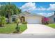 Inviting one-story home with a manicured lawn, lush landscaping, and a two-car garage at 630 Heather Glen Loop, Winter Haven, FL 33884