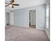 Carpeted bedroom features a ceiling fan and ensuite bathroom at 648 Lorient Dr, Eagle Lake, FL 33839